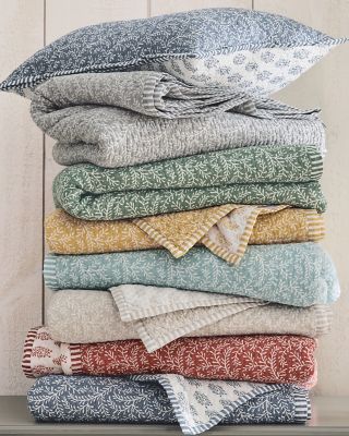 A stack of our Reversible Voile Quilts in various colors. Shop quilts.