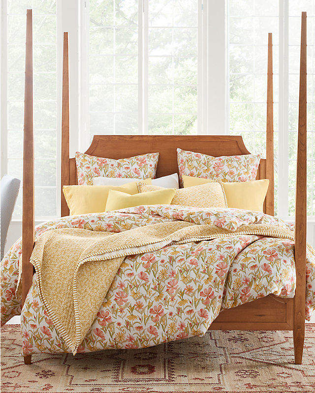 A bed with relaxed linen bedding in a floral print. Browse the home linen shop.