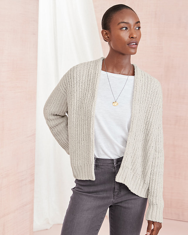 A woman in an off-white organic-cotton crimp cardigan sweater. Shop the Eileen Fisher Shop.